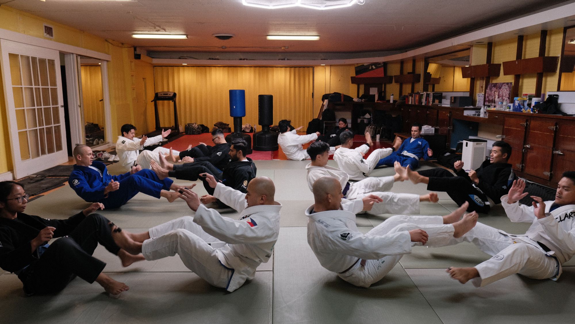 A full class of Project Clarito students warming up together on the mat at the Rizal Center.