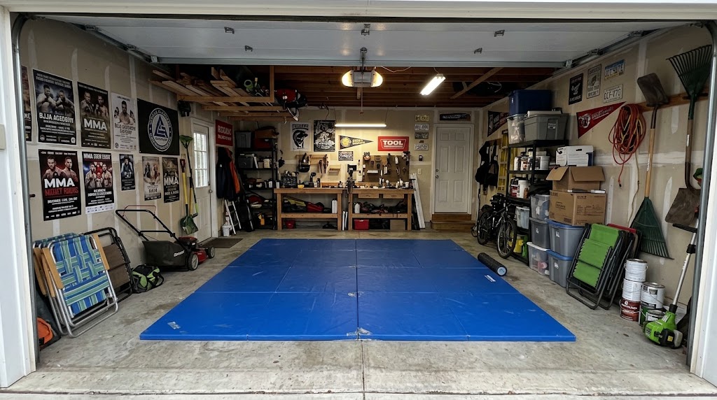 Roll-out BJJ mats set up in a home garage, ready for a private in-home training session.
